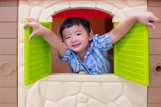 Photo portrait of cute boy in dollhouse