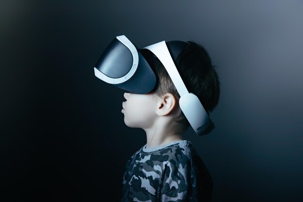 Portrait of cute boy looking away against black background