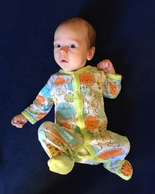 Portrait of cute boy lying down on bed