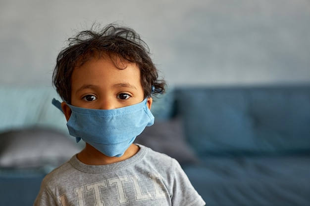 Portrait of a cute boy in mask at home