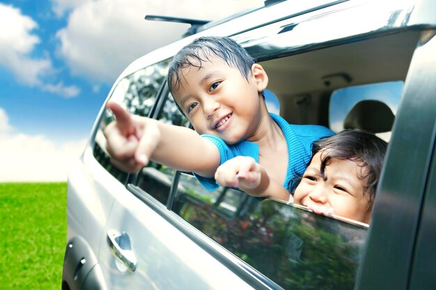 Portrait of cute boy playing by sister while sitting in car