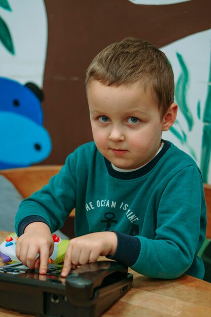 Photo portrait of cute boy playing with toy blocks