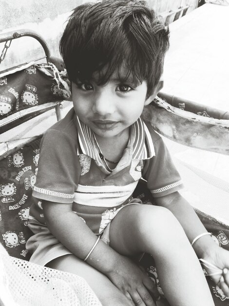 Photo portrait of cute boy sitting outdoors