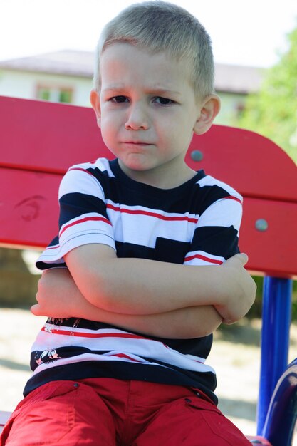 Photo portrait of cute boy sitting outdoors