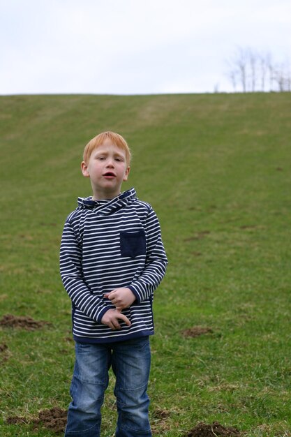 Photo portrait of cute boy standing on field