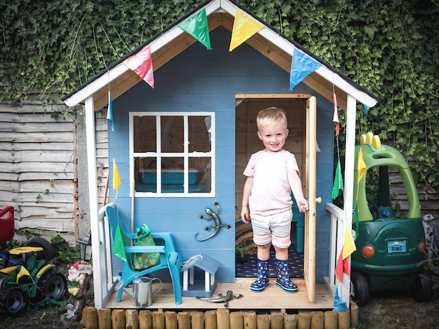 Photo portrait of cute boy standing in playhouse