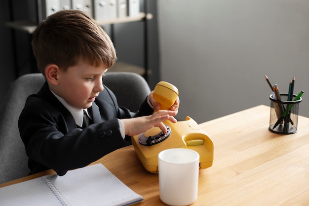 Foto ritratto di ragazzo carino con telefono rotante al lavoro nel suo ufficio