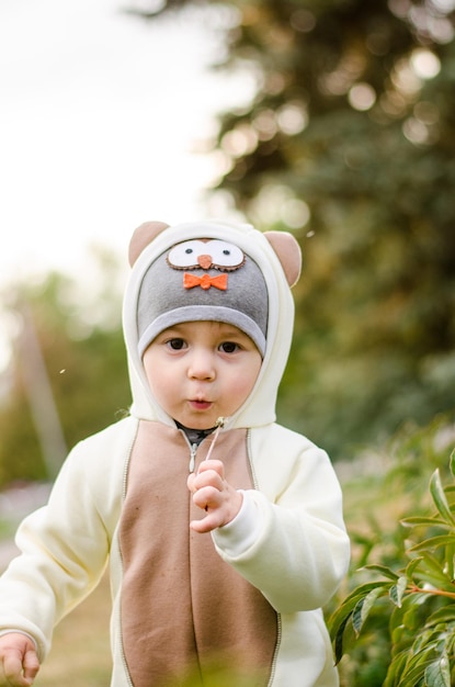 Photo portrait of cute boy in warm clothing while standing by plants