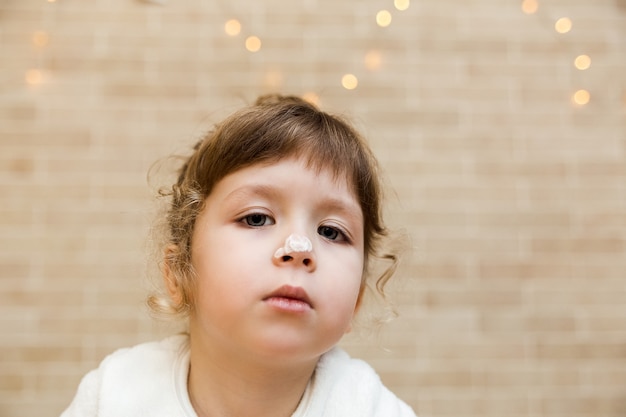 Portrait of cute brunette baby girl is preparing in kitchen Funny little girl is covered in flour