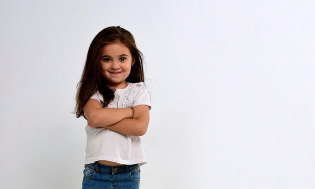 Portrait of cute caucasian little girl with arms crossed, beautiful happy child smiling and laughing