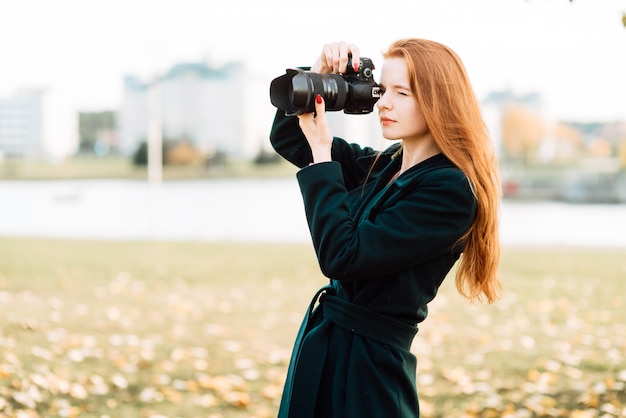 Portrait of a cute cheerful young girl holding a camera