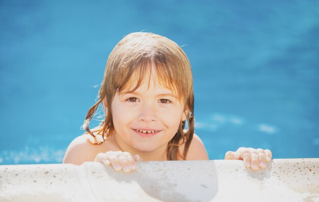 Portrait of a cute child boy in swimming pool close up caucasian kids face closeup head of funny kid