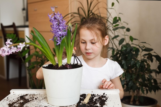 Portrait of a cute child girl caring for home plants