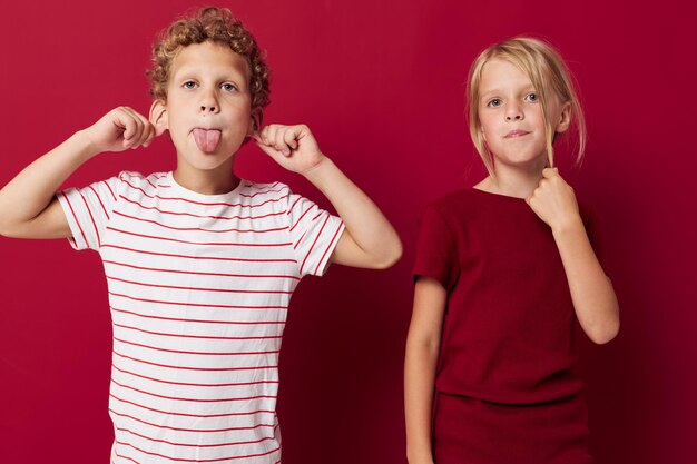 Portrait of cute children good mood standing next to posing on colored background