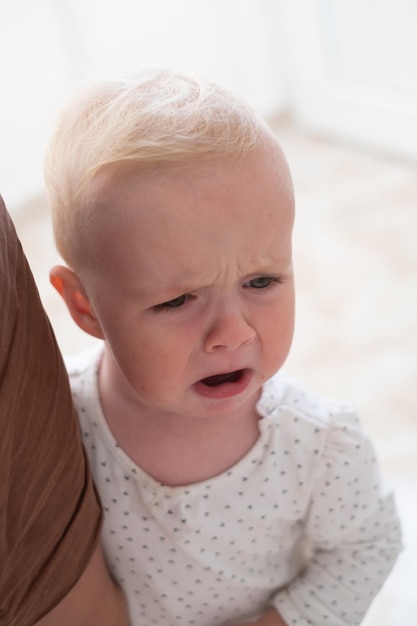 Portrait of cute crying baby afraid to go to the doctor