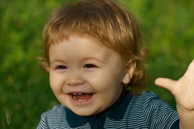 Portrait of cute excited boy having fun in garden baby face close up funny little child closeup port