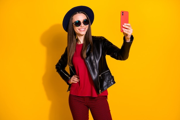 Portrait of cute fashionable girl taking making selfie on phone