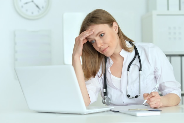 Portrait of  cute female doctor with laptop