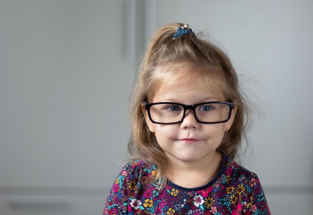 Portrait of cute and funny child wearing eyeglasses looking at camera