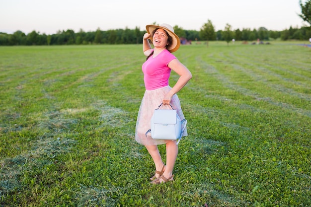 Photo portrait on cute funny laughing or surprised woman with backpack and hat