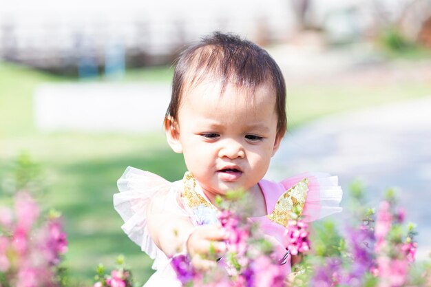 Portrait of cute girl against white flowering plants