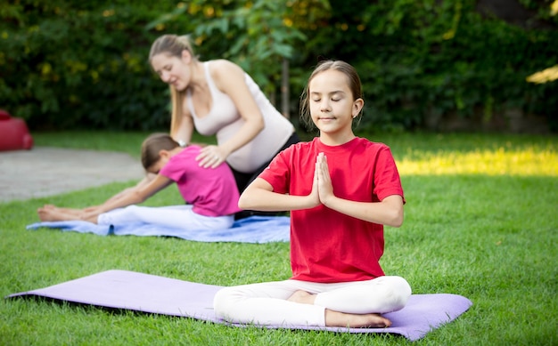 Portrait of cute girl doing yoga during outdoor lesson at park