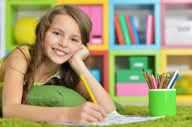 Portrait of cute girl drawing in her room