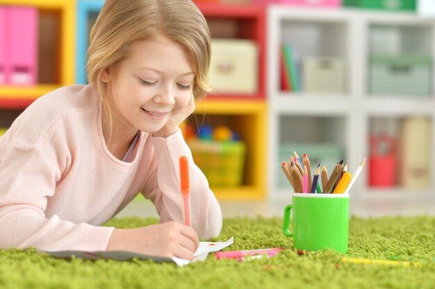 Portrait of a cute girl drawing at home