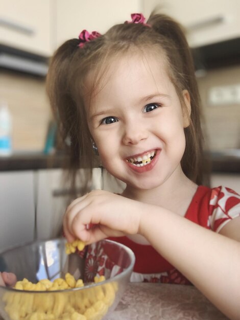 Photo portrait of cute girl eating food at home