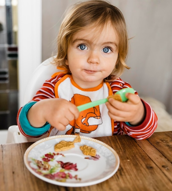 Photo portrait of cute girl eating food at home