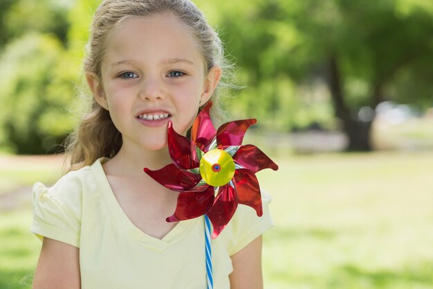 Портрет симпатичная девочка держит pinwheel в парке