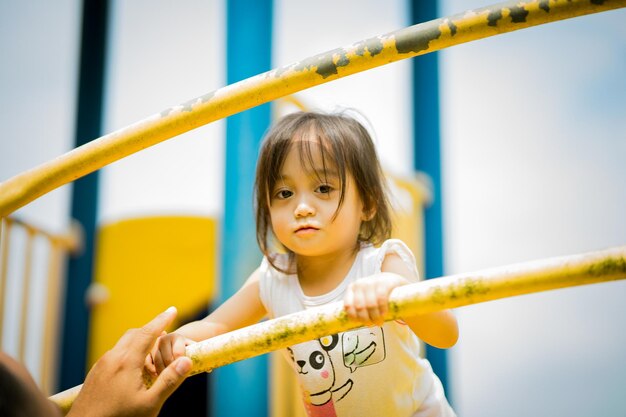 Portrait of cute girl holding standing with hand by railing