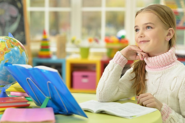 Портрет милой девушки, опирающейся на руку во время выполнения домашнего задания
