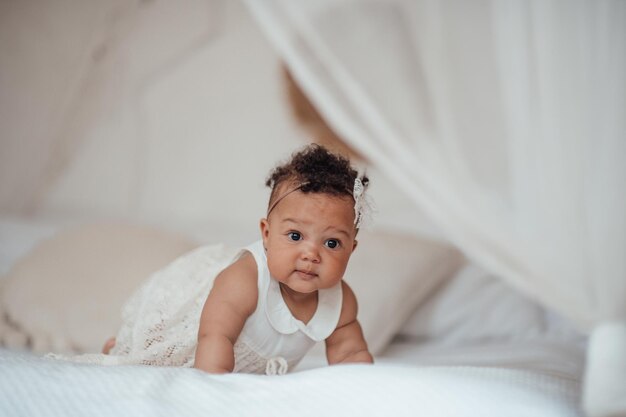 Photo portrait of cute girl lying on bed at home