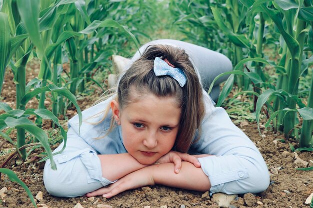 Photo portrait of cute girl lying on land