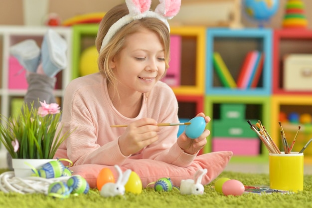 Portrait of a cute girl paint Easter eggs