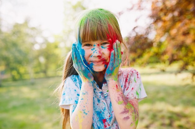 귀여운 소녀의 초상화는 Holi 축제의 색상으로 색칠.