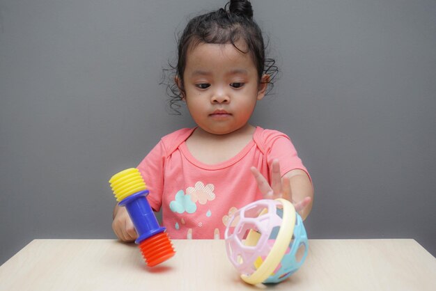 Portrait of cute girl playing with ball on table