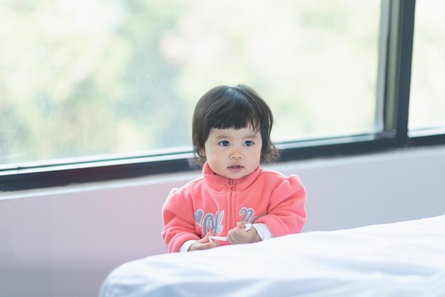 Portrait of cute girl sitting on bed