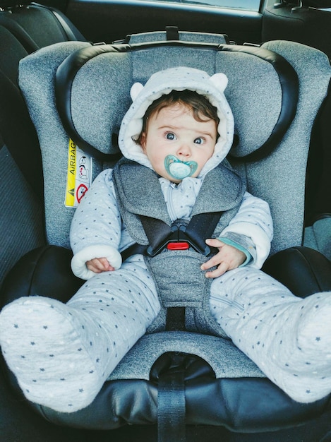 Portrait of cute girl sitting on car seat