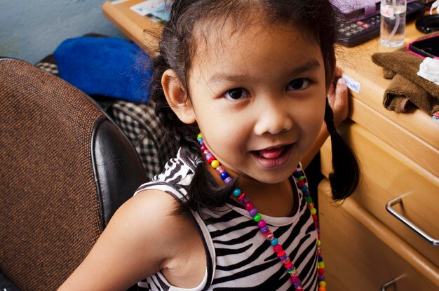 Photo portrait of cute girl sitting on chair