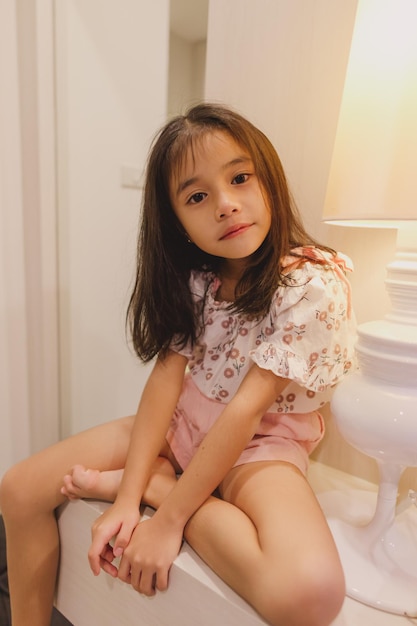 Photo portrait of cute girl sitting at home