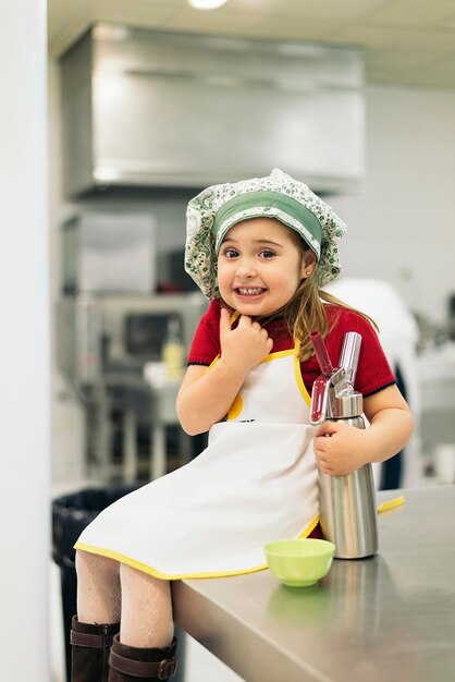 Photo portrait of cute girl sitting on kitchen counter