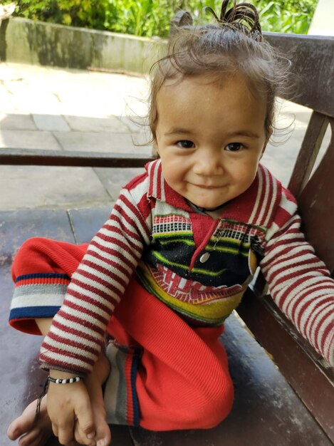 Portrait of cute girl sitting outdoors