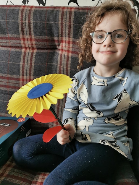 Portrait of cute girl sitting on sofa at home