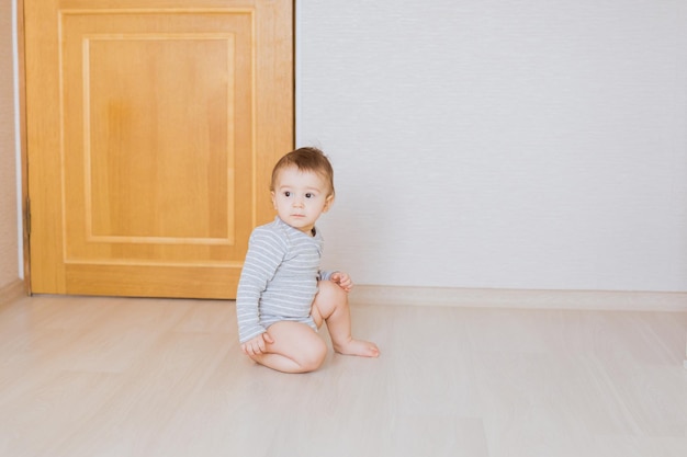 Portrait of cute girl sitting on wooden floor at home