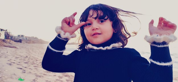 Portrait of cute girl standing against sky