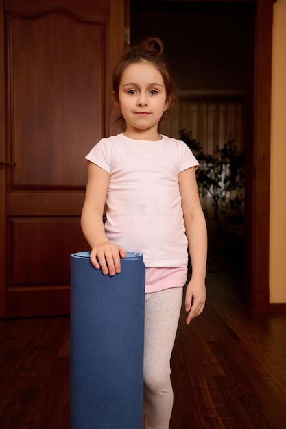 Portrait of cute girl standing on hardwood floor at home