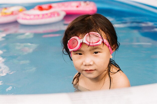 Photo portrait of cute girl in swimming pool