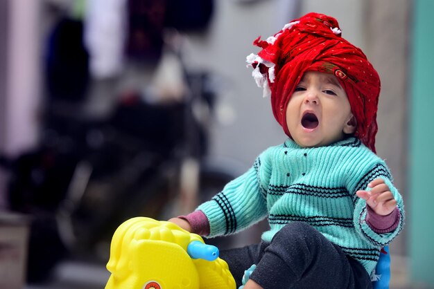 Photo portrait of cute girl wearing turban yawning at home